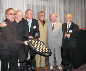 Sechs Fernschach-Weltmeister aus aller Welt halten sich freundschaftlich umarmt! Ein Bild, welches im Nahschach nicht möglich wäre!